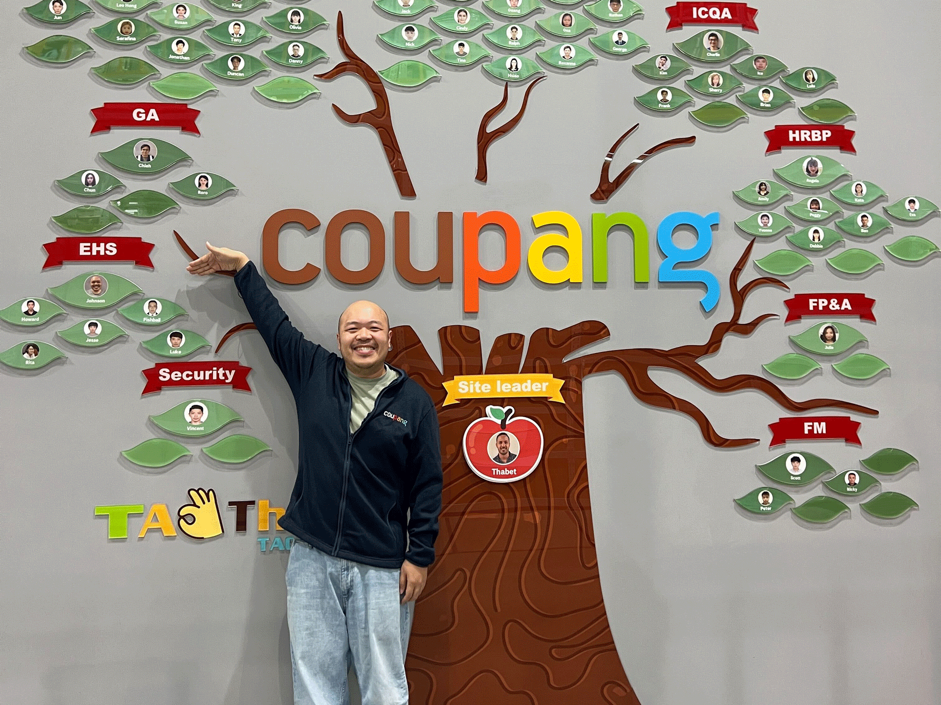 a person standing in front of a wall with a tree and persony images