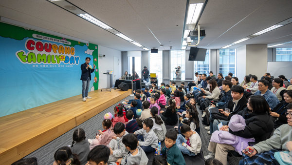 한 무리의 아이들이 그 앞에 앉아 있는 무대 위의 사람