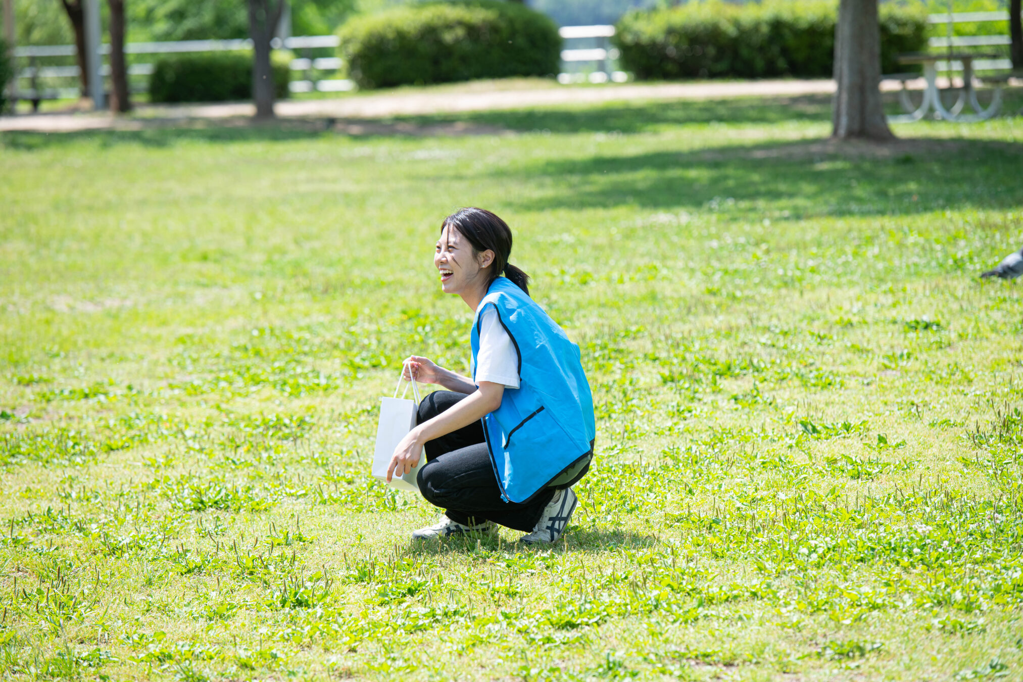 가방을 들고 풀밭에 무릎을 꿇고 있는 사람