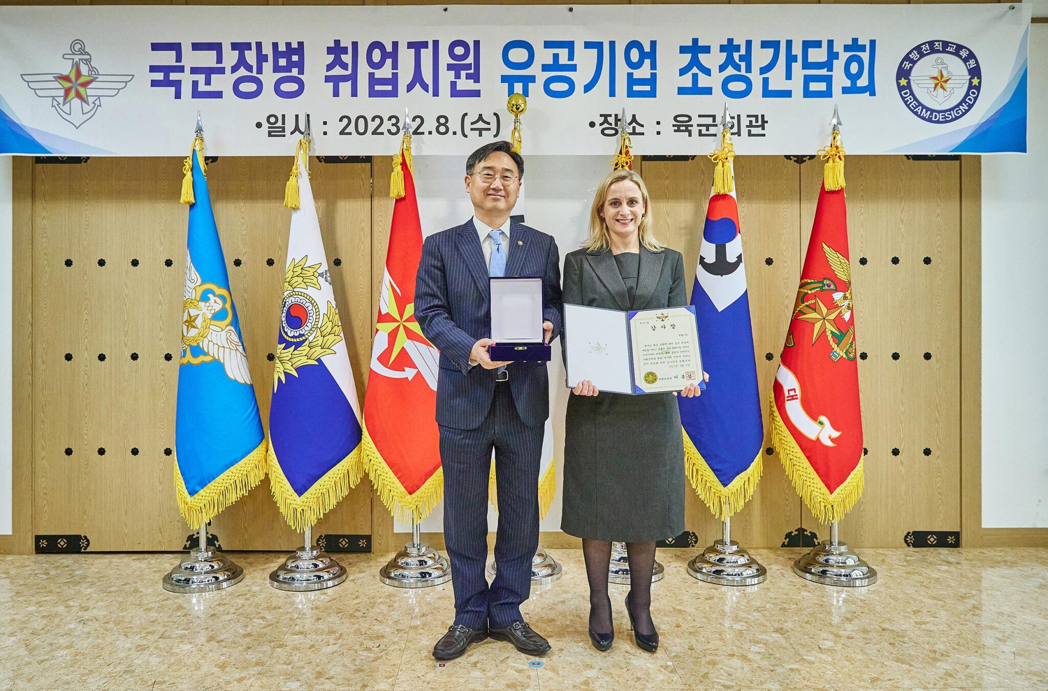 증명서를 들고 깃발 앞에 서 있는 사람과 사람