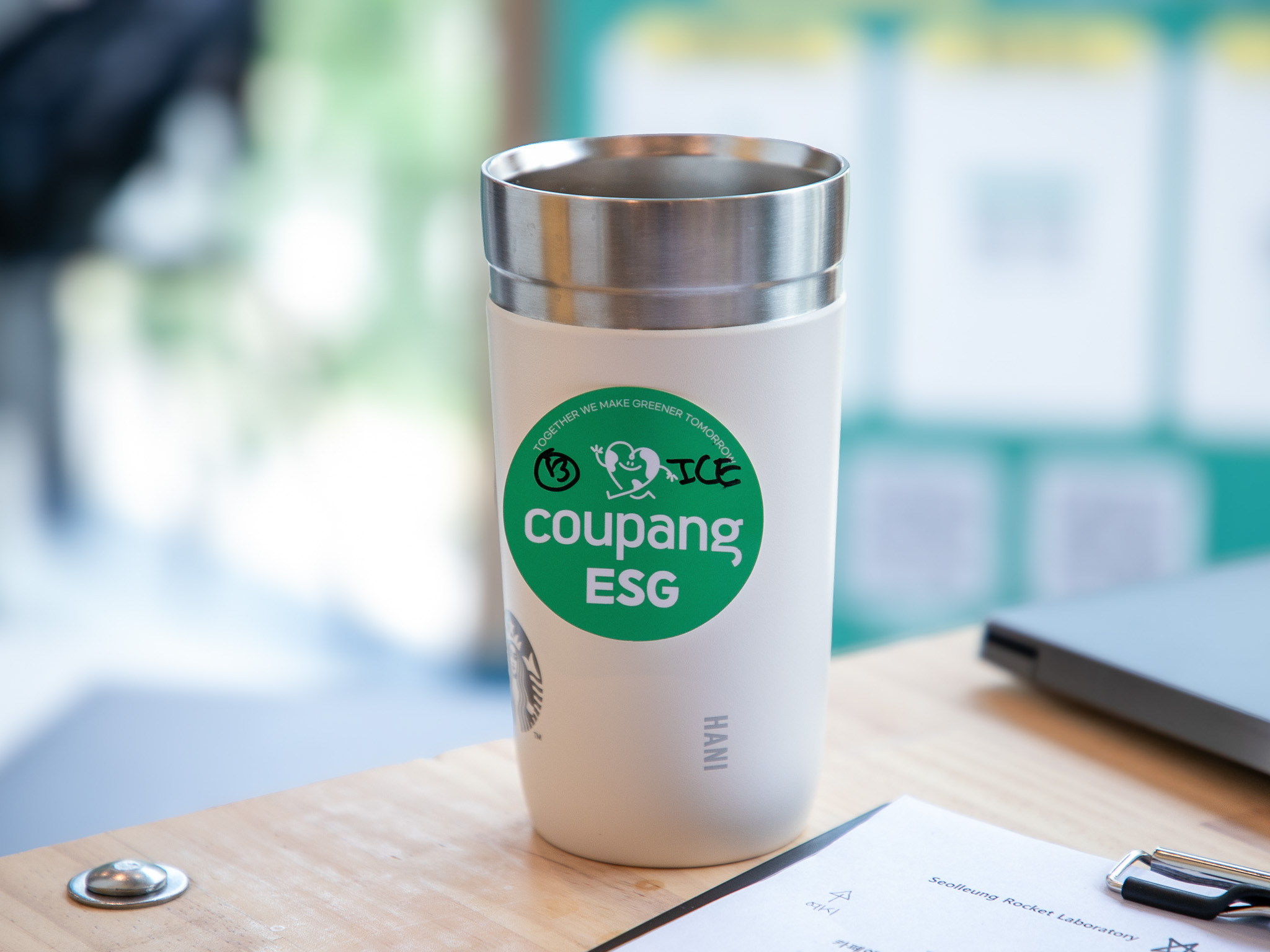 테이블 위의 흰색과 초록색 컵