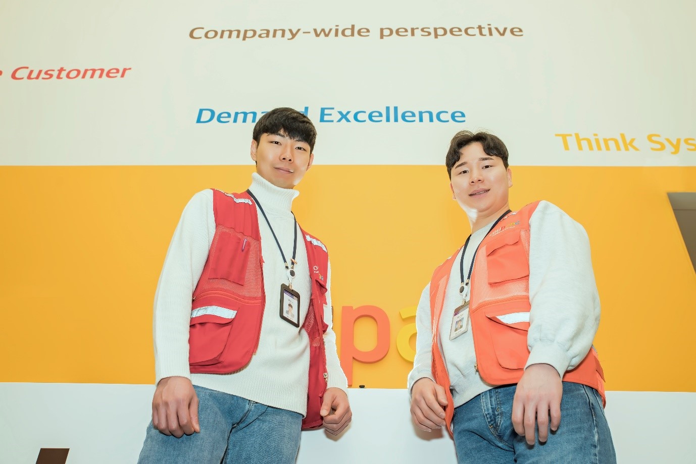 노란 벽 앞에 서 있는 두 남자