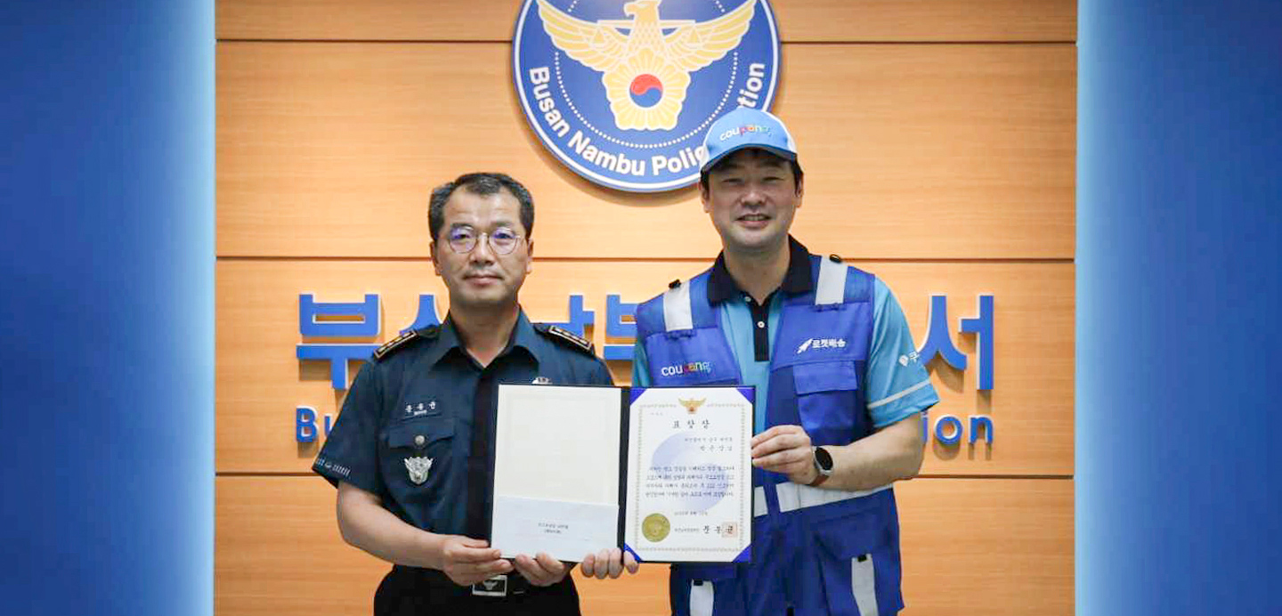 제복을 입은 두 남자가 증명서를 들고 있다