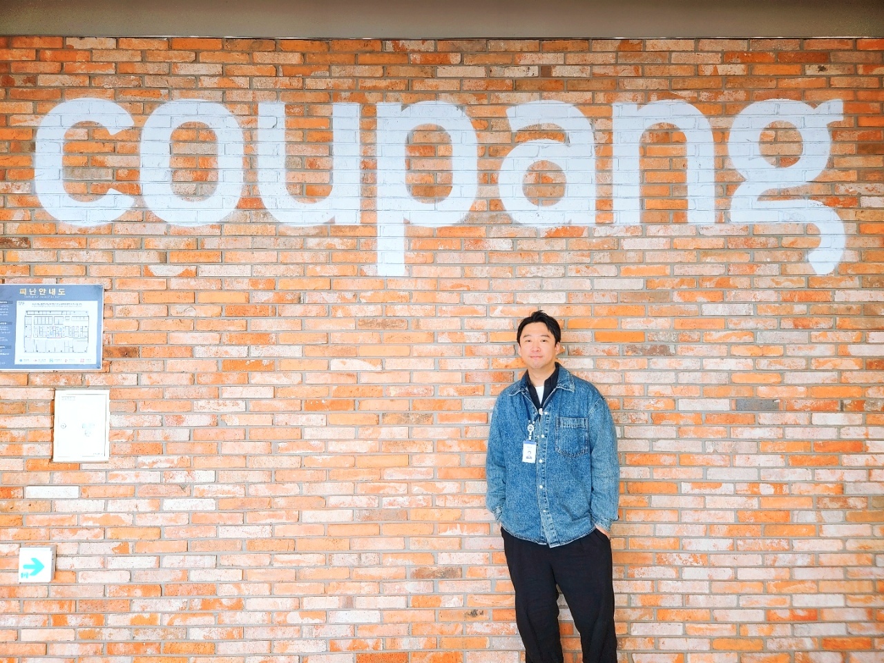 a person standing in front of a brick wall
