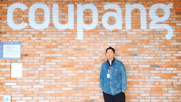 a person standing in front of a brick wall