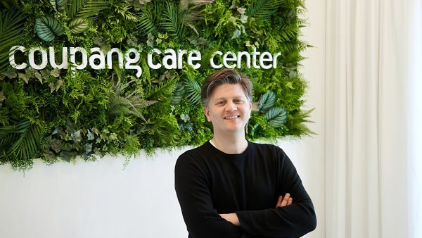 a person standing in front of a green wall