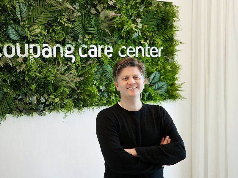 a person standing in front of a green wall