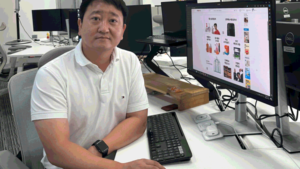 컴퓨터가 있는 책상에 앉아 있는 사람