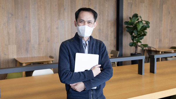 마스크를 착용하고 노트북을 들고 있는 사람