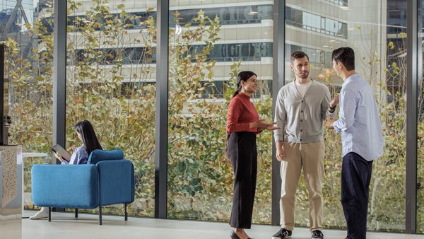 창문이 있는 방에 서 있는 한 무리의 사람들