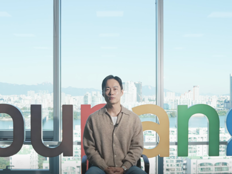 큰 창문 앞에 앉아있는 사람
