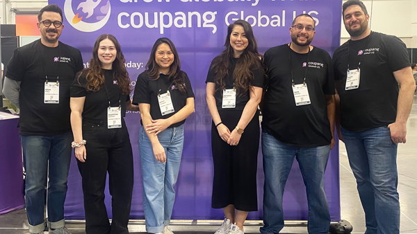 a group of people standing in front of a purple sign