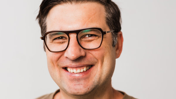 a person wearing glasses smiling