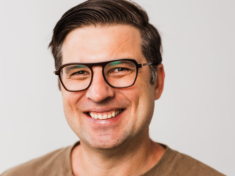 a person wearing glasses smiling