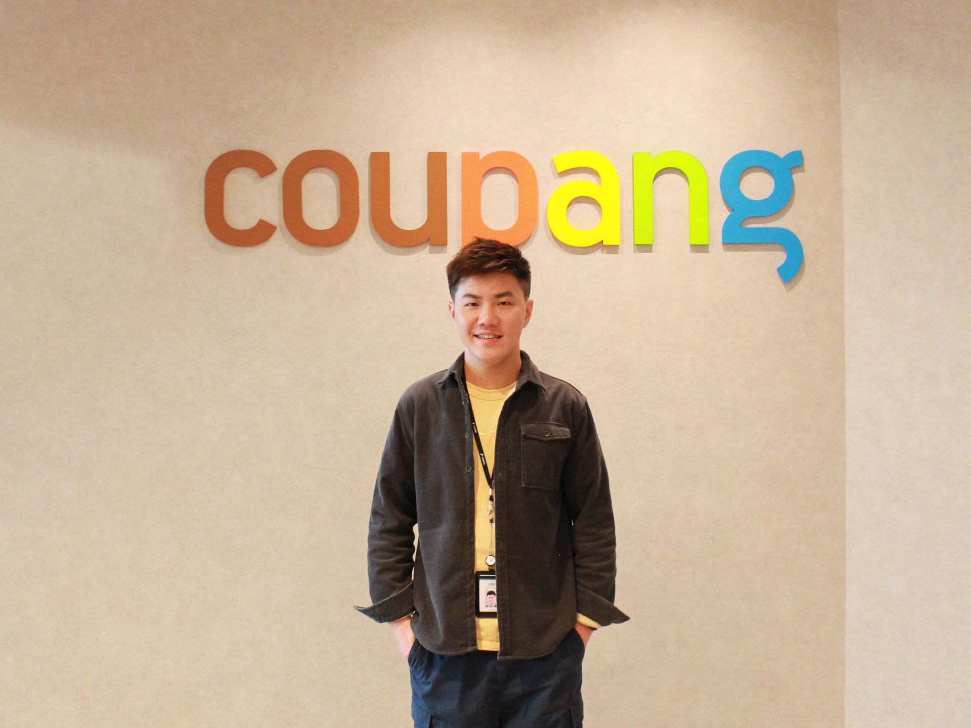 a person standing in front of a wall with colorful letters