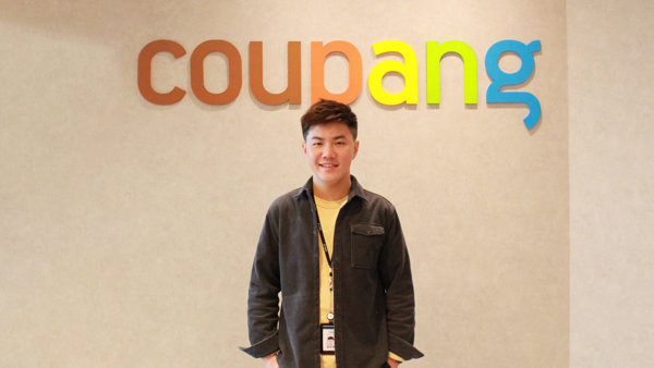 a person standing in front of a wall with colorful letters