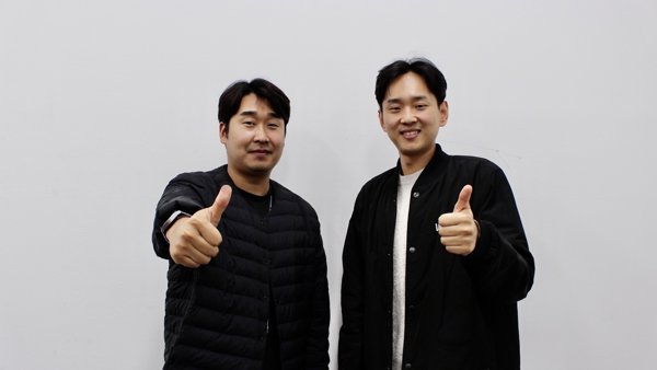 엄지손가락을 치켜세우는 두 남자