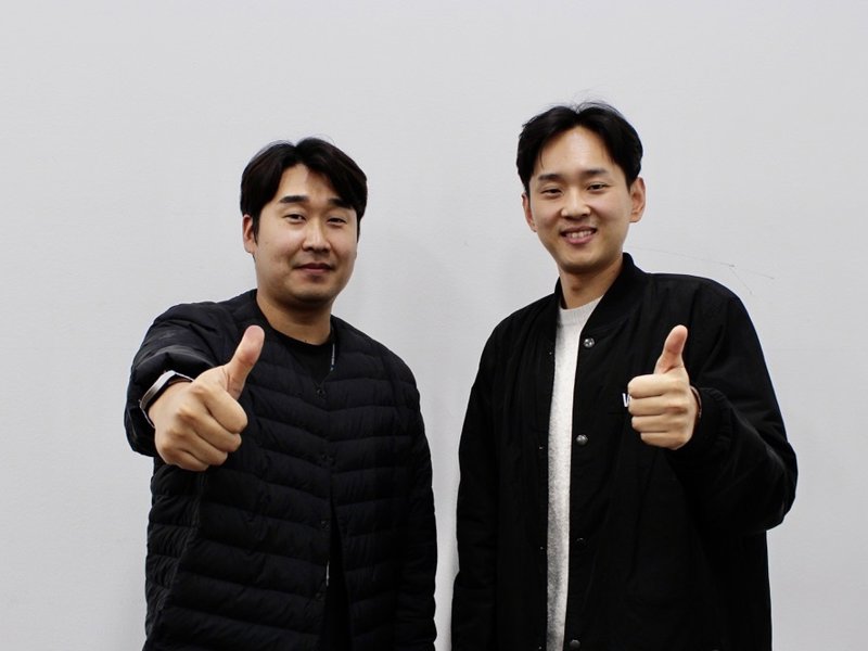 엄지손가락을 치켜세우는 두 남자
