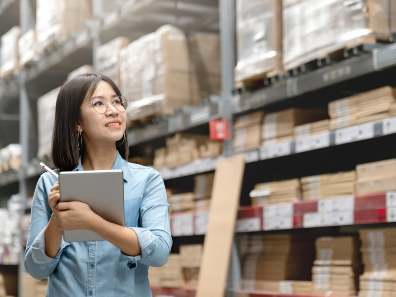 a person holding a tablet in a warehouse