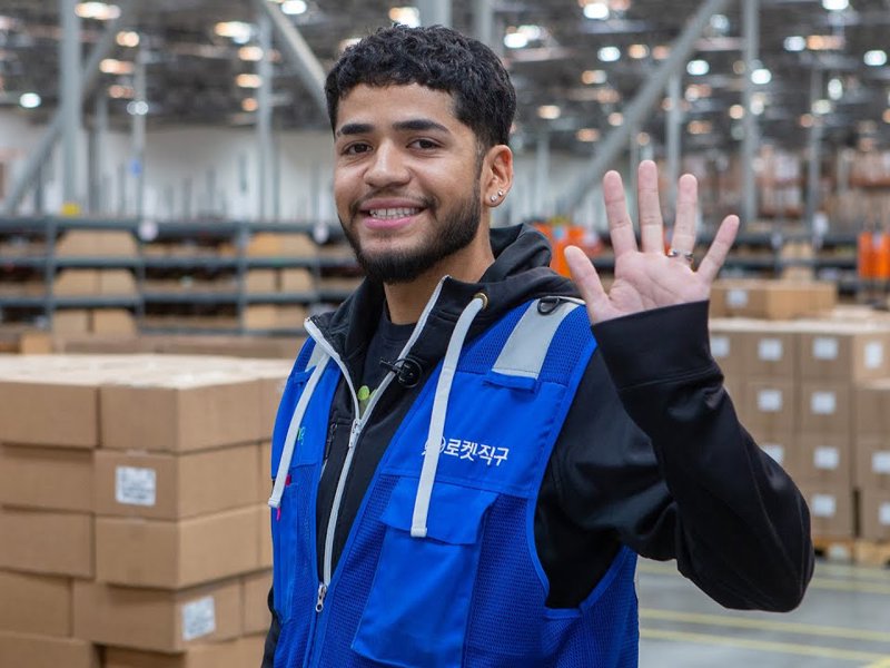 a person in a blue vest waving