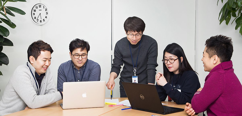 노트북을 보고 있는 한 무리의 사람들