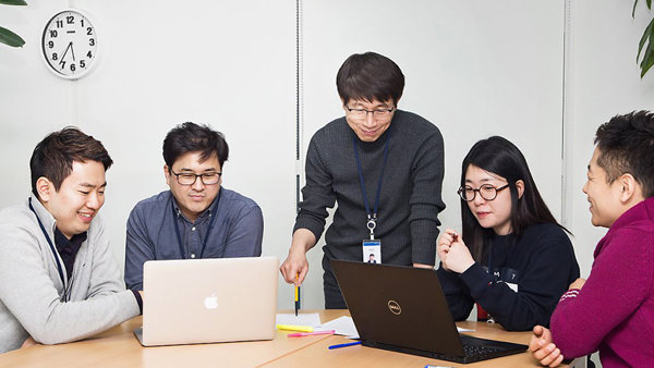 노트북을 보고 있는 한 무리의 사람들