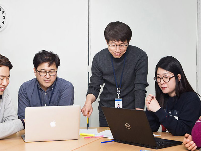 노트북을 보고 있는 한 무리의 사람들