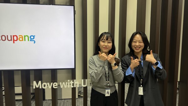 스크린 앞에 서 있는 두 명의 여성