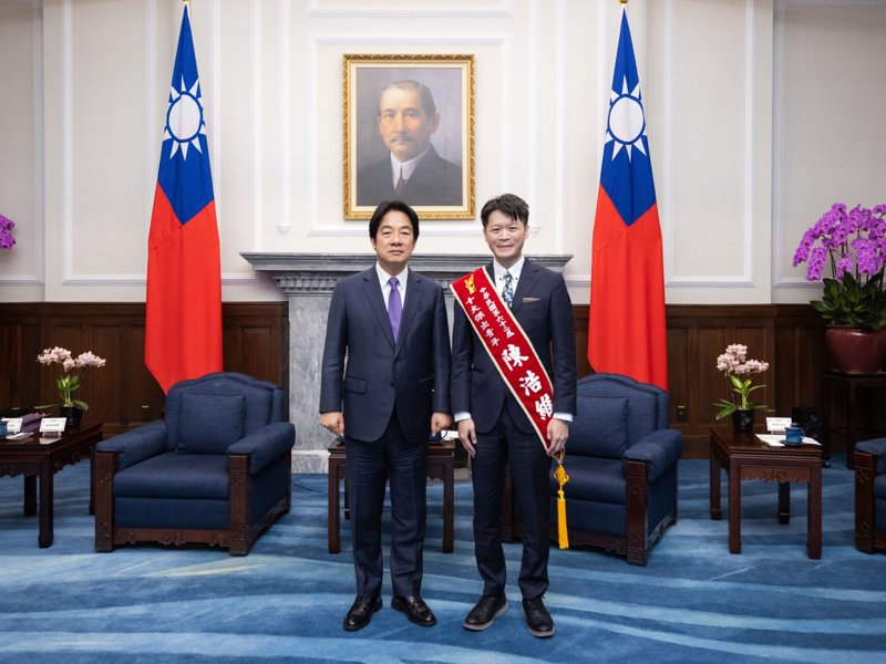兩個西裝革履的男人站在一個房間里,房間里有旗幟和一張人的照片