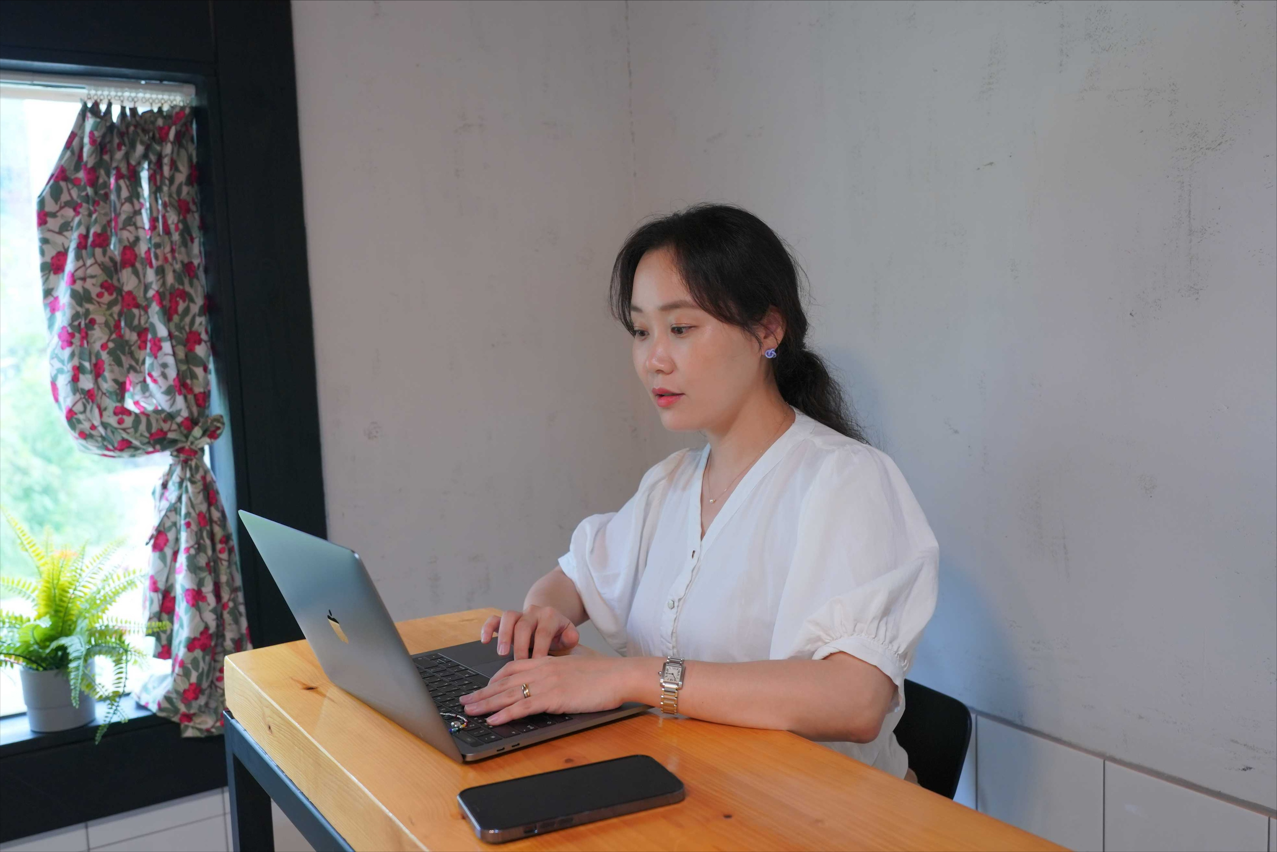 a person sitting at a desk using a laptop