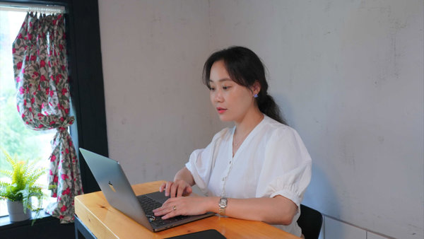 a person sitting at a desk using a laptop