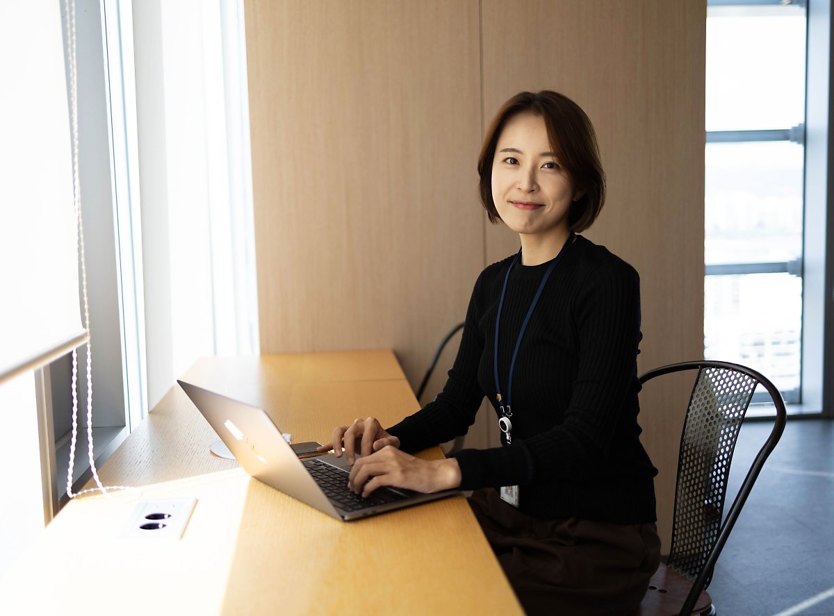 책상에 앉아 노트북을 사용하는 사람