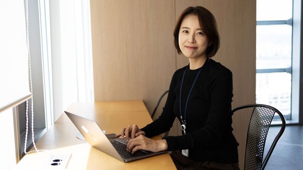 책상에 앉아 노트북을 사용하는 사람