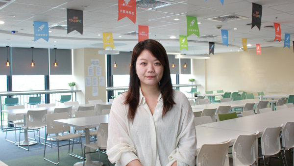 a person sitting in a room with tables and chairs