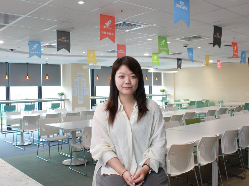 a person sitting in a room with tables and chairs