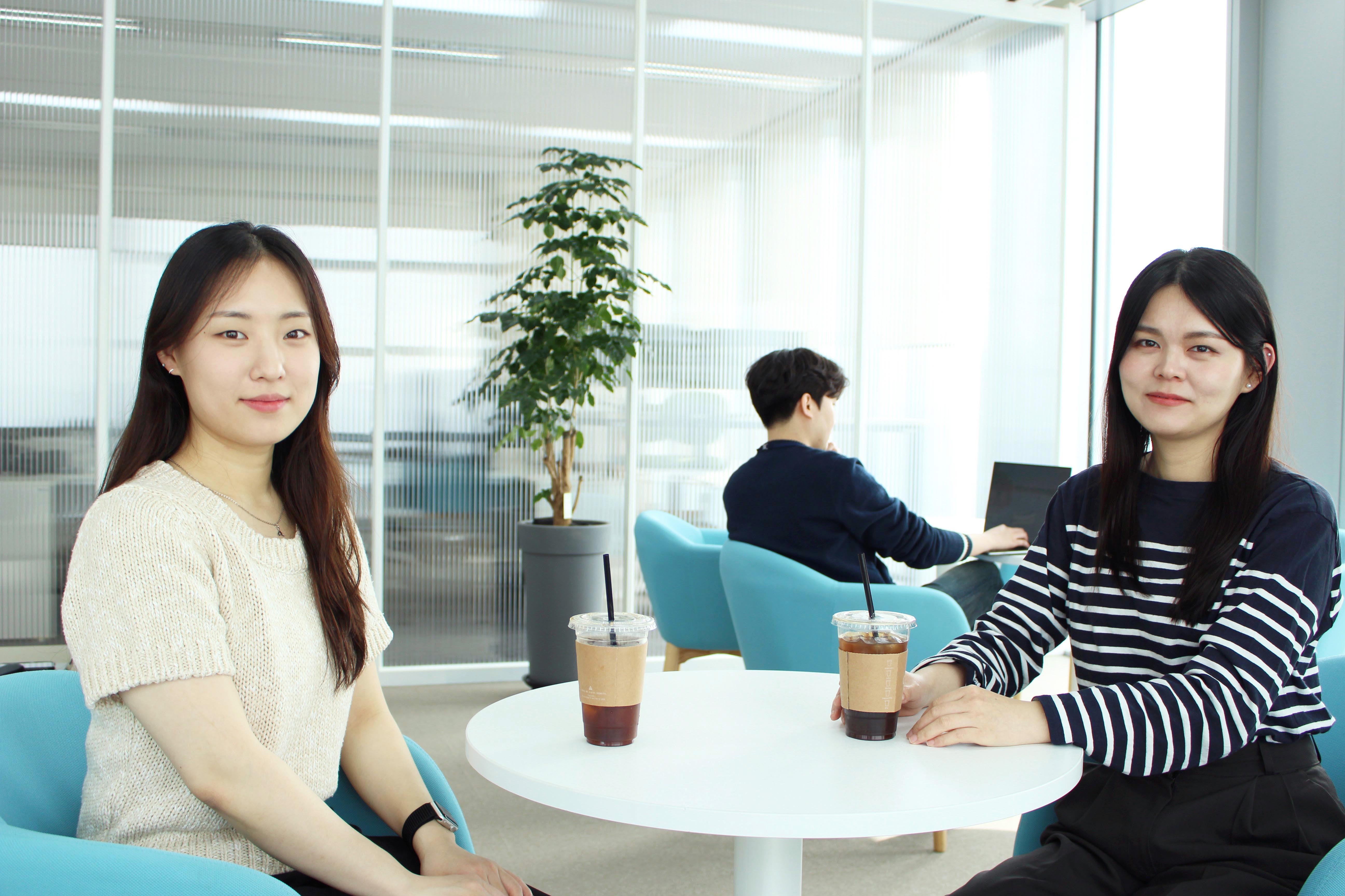 two women sitting at a table with drinks