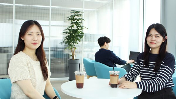 two women sitting at a table with drinks