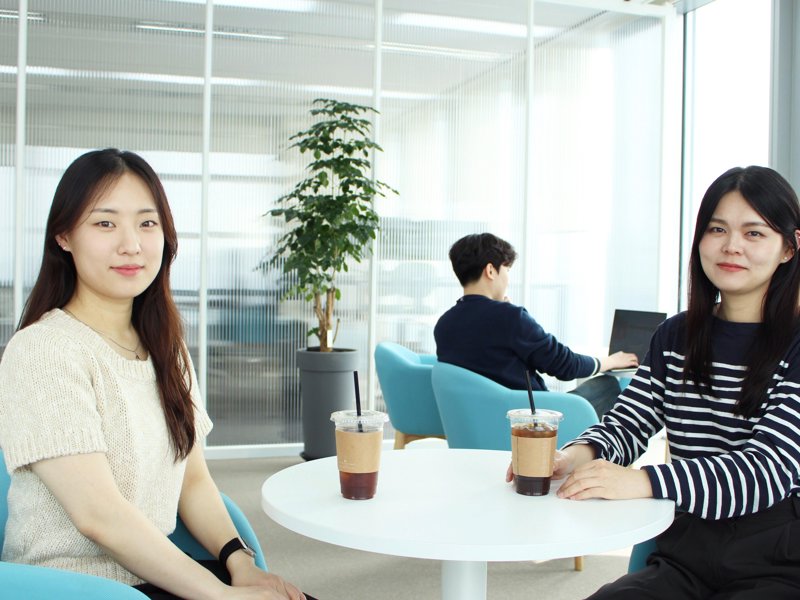 음료가 있는 테이블에 앉아 있는 두 명의 여성
