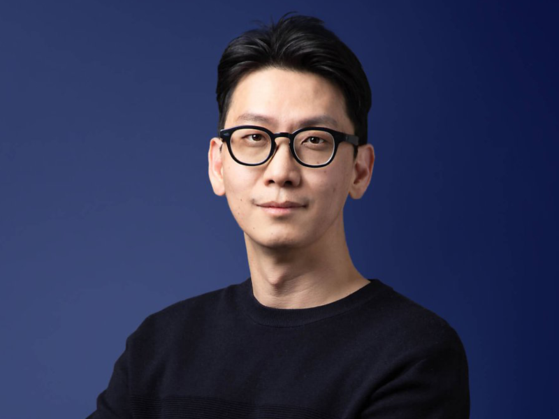 안경을 쓰고 검은 셔츠를 입은 사람